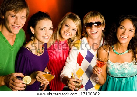 Portrait of five smiling friends with cocktails looking at camera