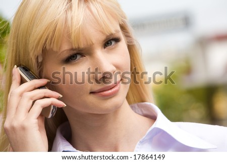 Portrait of modern female holding cell by her ear and looking at camera