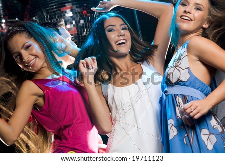 Three glamorous girls enjoying themselves while dancing in night club