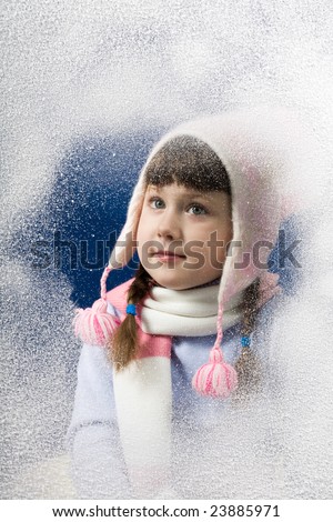 Photo of pretty little girl behind frosted window looking through it