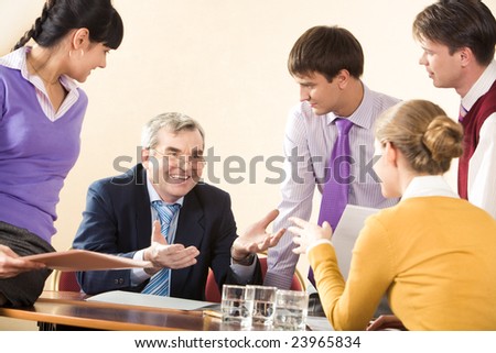 Group of successful managers communicating with senior boss at meeting