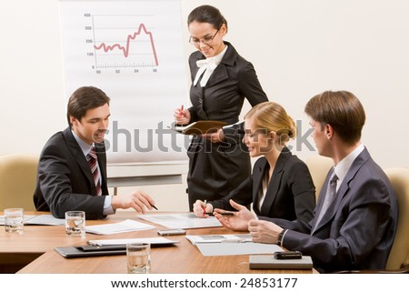 Image of business team looking at document and discussing it in office