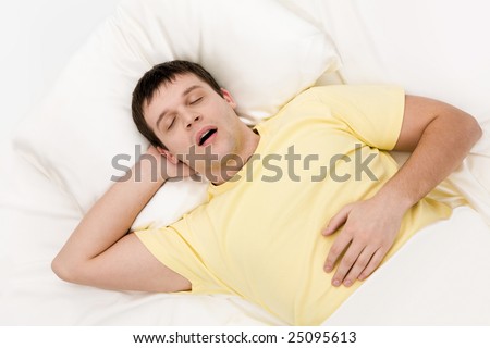View from above of tired man snoring while deep sleep in bed