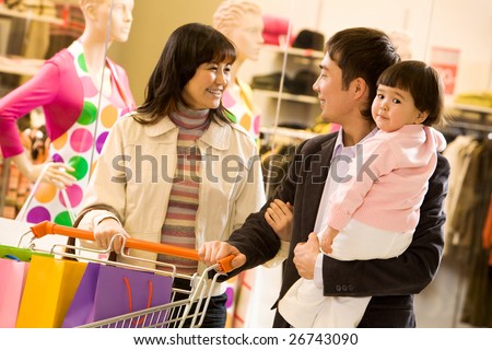 Portrait of friendly family shopping together with shop window at background