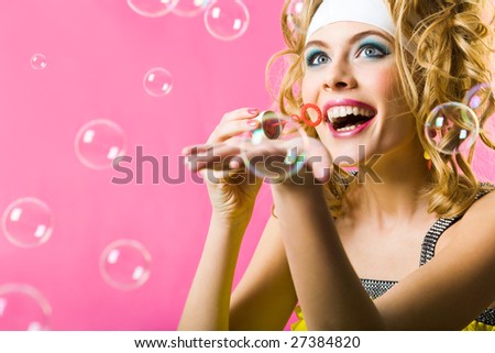 Photo of happy girl having fun while blowing soap bubbles