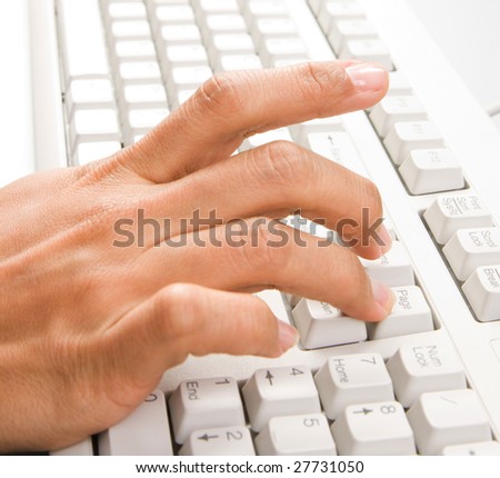 Close-up of female hand over keyboard pushing its buttons