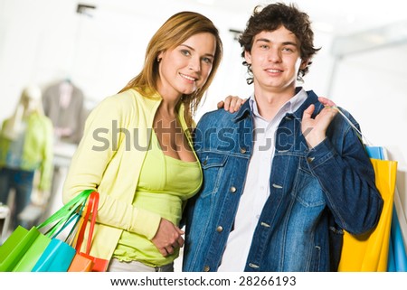 Portrait of amorous couple looking at camera with smiles after great shopping