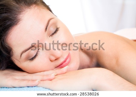 Beautiful woman with her eyes shut having rest in the spa salon