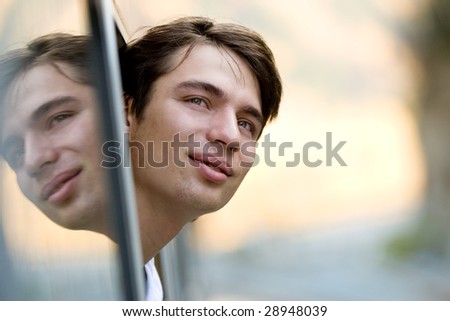 Photo of young commuter looking out of train window during journey
