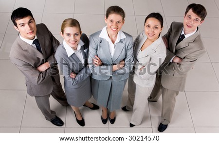 Portrait of confident business group standing on the floor and looking at camera with smiles