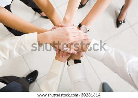 Above view of business partners hands on top of each other symbolizing teamwork and respect