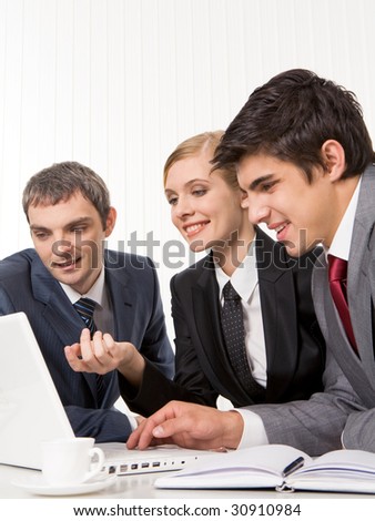 Portrait of executive employees planning work and looking at laptop monitor during meeting