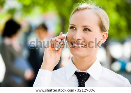 Portrait of pretty business leader talking by mobile phone with smile