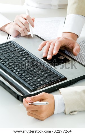 Photo of human hands near laptop at workplace during meeting