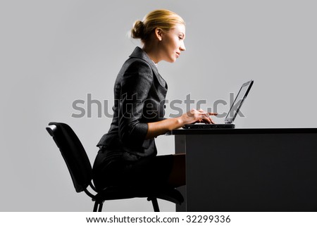stock photo Photo of pretty secretary typing on laptop at workplace