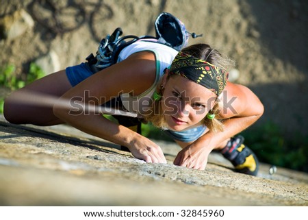 Image of pretty woman climbing on the rock