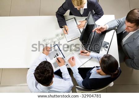 Image of company of successful partners discussing contract at meeting
