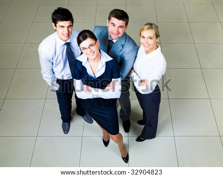 Portrait of four business persons standing in the office