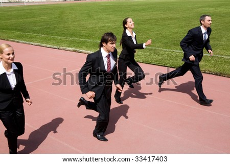 Photo of business people running on sport track