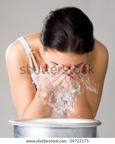 Image of isolated woman washing her face from wash-basin
