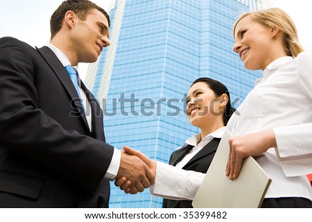 Business partners handshaking after negotiating and signing contract