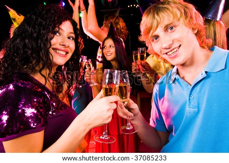Portrait of happy couple with flutes of champagne toasting at birthday party