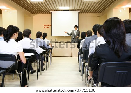 Image of confident businessman explaining something on whiteboard during conference