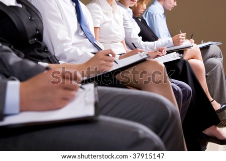 Close-up of business people making notes or writing business plan at conference