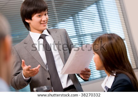 Photo of confident businessman explaining his idea to colleagues in office