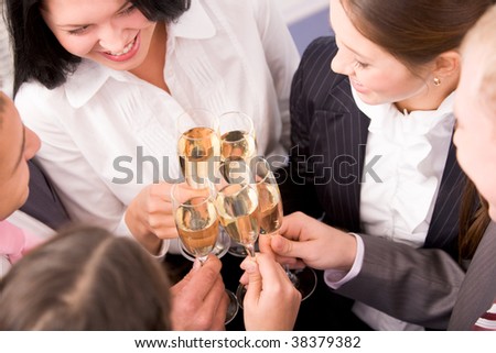 Photo of happy colleagues holding champagne flutes at corporate party