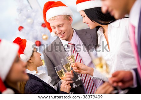 Image of cheering friends in Santa caps making toast at corporate party