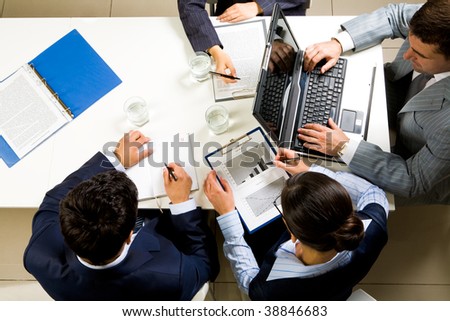 Image of company of successful partners planning work at meeting