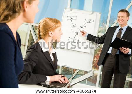Image of young manager presenting speech to his colleagues