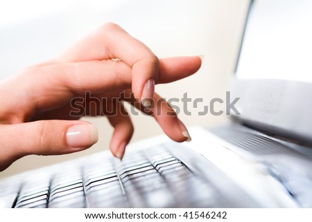 Close-up of female hand keeping forefinger bound while pointing at laptop display