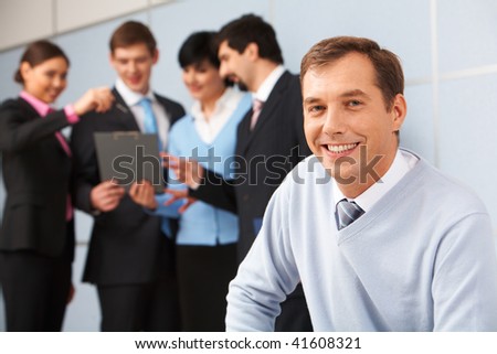 Photo of happy man looking at camera in working environment