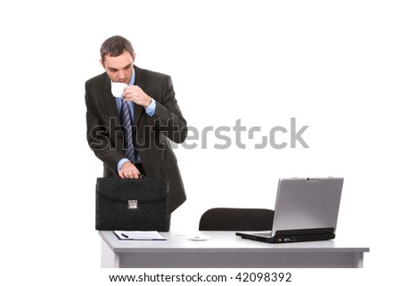 Portrait of smart businessman looking at laptop monitor with cup of coffee in hand