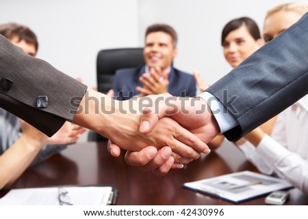 Photo of successful business partners handshaking after striking great deal with applauding people at background