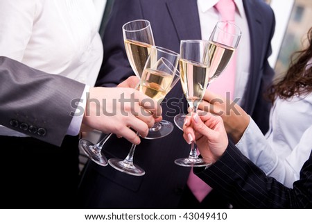 Close-up of human hands cheering up with flutes of sparkling champagne
