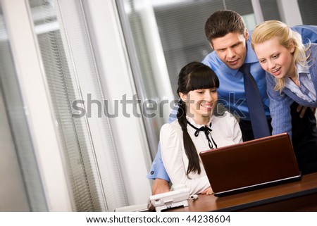 Group of confident employees looking at monitor while planning work in office