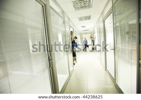 Photo of business people looking out of workshops in office building