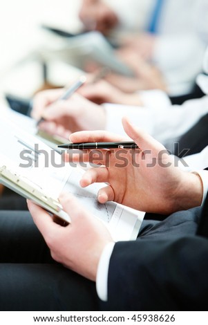 Business person hand with pen learning document during lecture
