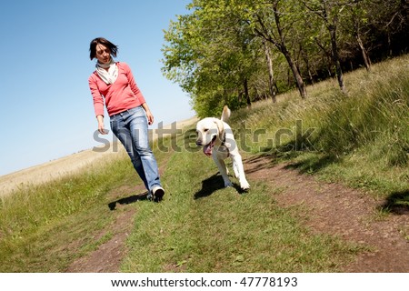 Photo of girl and labrador walking on the road
