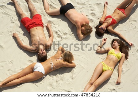 stock photo Above view of young slip teens sunbathing at beach