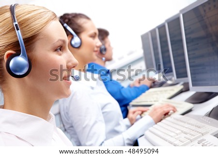 Row of telephone operators looking at the monitor and working