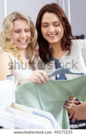 Image of pretty girls chosing clothes in the department store - stock