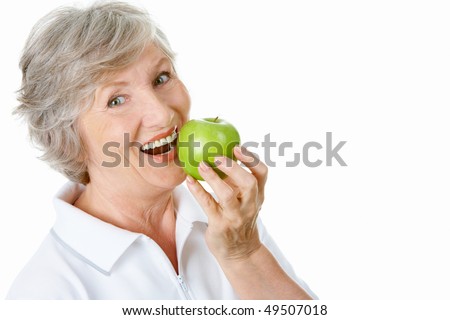 Portrait of senior woman holding an apple by her mouth