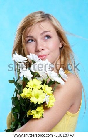 Portrait of pretty girl with spring flowers on blue background