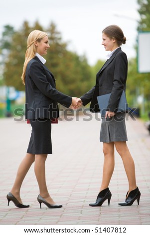 Photo of partnership - business women shaking hands at meeting