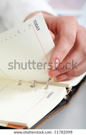 Close-up of female hand turning page of notepad