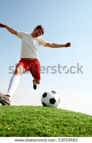 soccer player kicking ball. stock photo : Portrait of soccer player kicking ball on football field